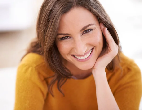 Disfrutando de un día perezoso en casa. Retrato de una mujer sentada en el interior apoyando la cabeza sobre la mano. — Foto de Stock