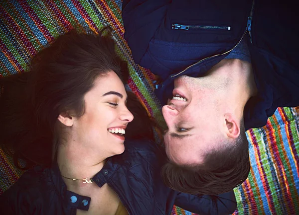C'est un jour réservé pour l'amour. Prise de vue d'un jeune couple heureux allongé sur une couverture à l'extérieur. — Photo