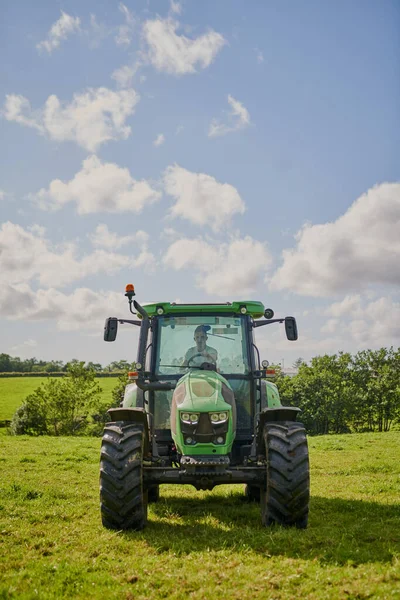 Cada granjero necesita uno. Tiro de longitud completa de un tractor verde en un pedazo abierto de tierras de cultivo. — Foto de Stock