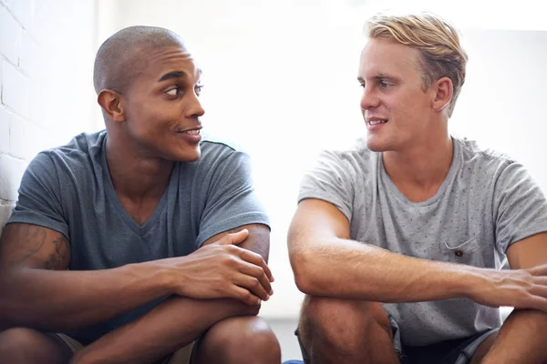 Falar com um amigo antes da aula. Tiro de estudantes universitários do sexo masculino sentados e falando antes da aula. — Fotografia de Stock