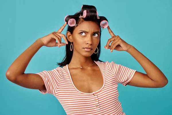 Adoro o meu cabelo em cachos saltitantes. Tiro de uma jovem mulher com rolos no cabelo filmado contra um fundo de estúdio. — Fotografia de Stock