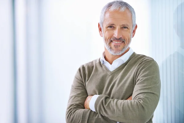 Prendre soin des affaires avec un sourire. Portrait d'un homme d'affaires mature debout dans un bureau. — Photo