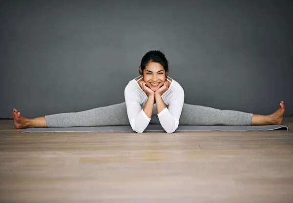 Meg fogsz lepődni, hogy mire képes a tested. Egy vonzó fiatal nő portréja, aki spárgázik a jóga gyakorlatában.. — Stock Fotó