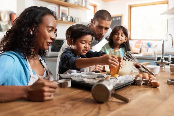 Ik wil wat extra honing in de mijne. Gehakt schot van een jong paar bakken thuis met hun twee kinderen. — Stockfoto