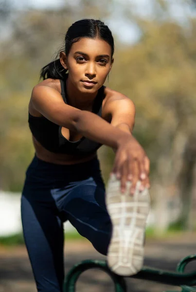 İyi esnemek yaralanma riskini önler. Açık havada egzersiz yaparken bacaklarını açan genç bir kadının portresi.. — Stok fotoğraf