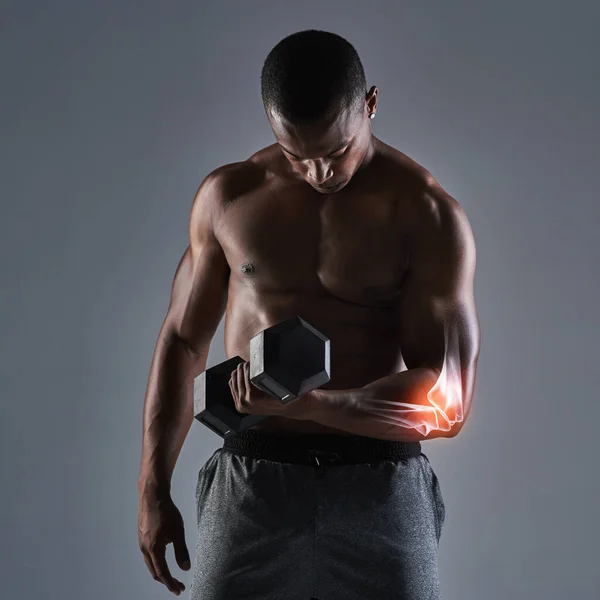 Een beetje druk op de elleboog. Gehakt schot van een atletische jongeman werken met een halter. — Stockfoto