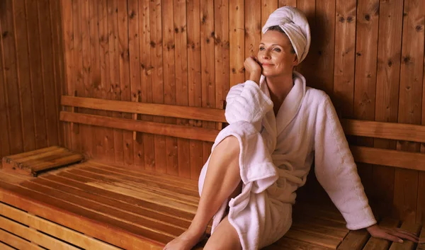 Aspettando che il vapore faccia la sua magia. Girato di una donna matura in una sauna. — Foto Stock