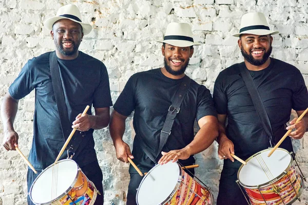 Luister naar onze Samba geluiden. Gesneden portret van een groep knappe jonge mannelijke drummers die op Carnaval spelen. — Stockfoto