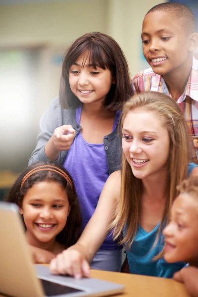 La tecnologia fa tutto parte dell'esperienza di apprendimento. Un gruppo di alunni che lavorano su un computer portatile in classe. — Foto Stock