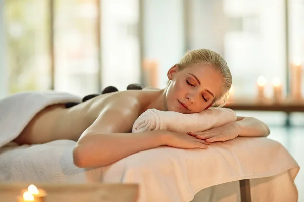 À deriva nos tempos de tranquilidade. Tiro recortado de uma jovem mulher desfrutando de uma massagem de pedra quente em um spa. — Fotografia de Stock