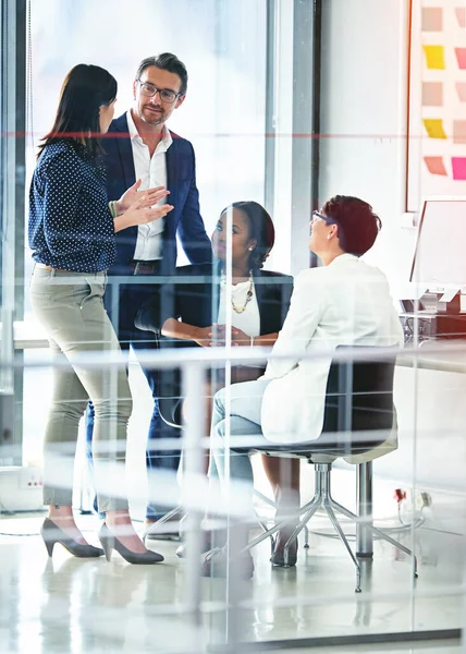 Déjame explicarte. Imagen completa de cuatro colegas de negocios que trabajan en la oficina. — Foto de Stock