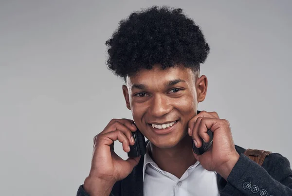 Zenét fel, hogy a dolgok megtörténjenek. Egy fiatal üzletember portréja, aki fülhallgatót használ szürke háttérrel. — Stock Fotó