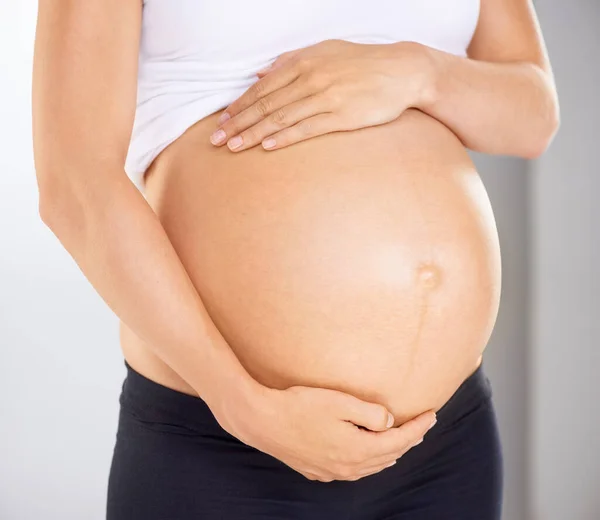 Ya te quiero. Imagen recortada de una mujer embarazada sosteniendo su estómago cariñosamente. — Foto de Stock