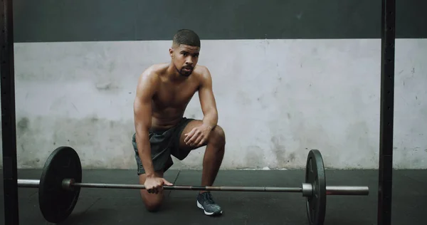 도전에 직면하면, 출구로 뛰어가지 마십시오. 근육질의 젊은 남자 가 체육관에서 초인종을 들고 운동하는 모습. — 스톡 사진