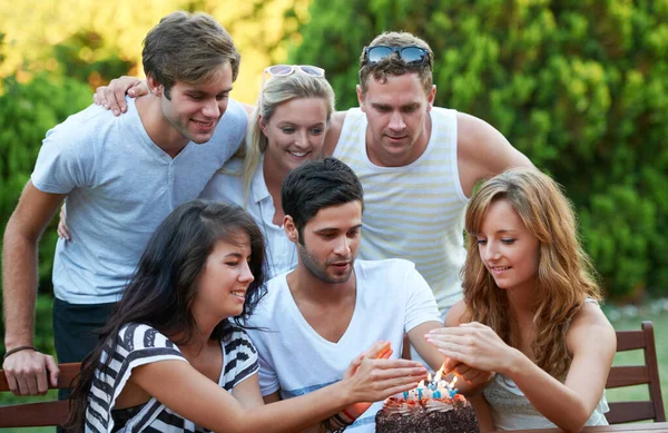 Maak je klaar om een wens te doen... Gelukkige jonge tiener vrienden vieren iemands verjaardag met een taart en kaarsen. — Stockfoto