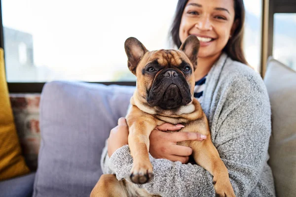 Una casa no es un hogar sin una linda compañera. Retrato de una joven mujer relajándose con su perro en casa. — Foto de Stock