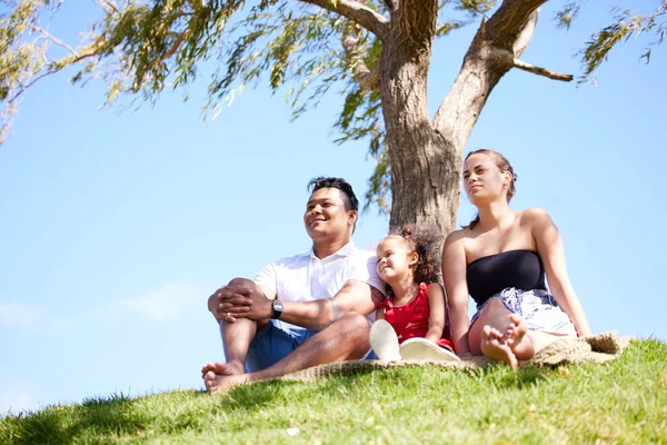 Er is altijd tijd voor een gezinsuitje. Shot van een klein meisje op een picknick in het park met haar ouders. — Stockfoto