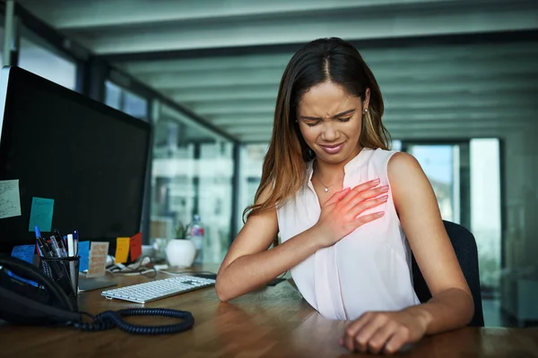 What was that sharp pain. Shot of a young businesswoman suffering with chest pain while working in an office. — Stock Photo, Image