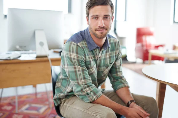 Jag förvandlar idéer till verklighet. Porträtt av en lättklädd ung man som sitter på ett kontor. — Stockfoto