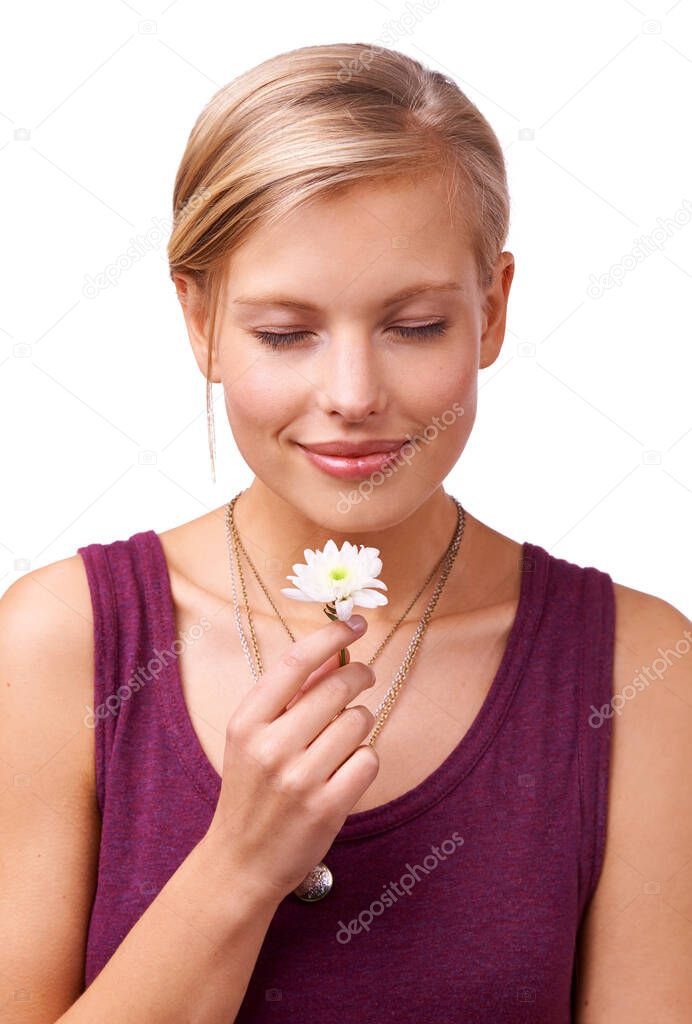 All natural aromatherapy. Studio shot of a young woman smelling a flower isolated on white.