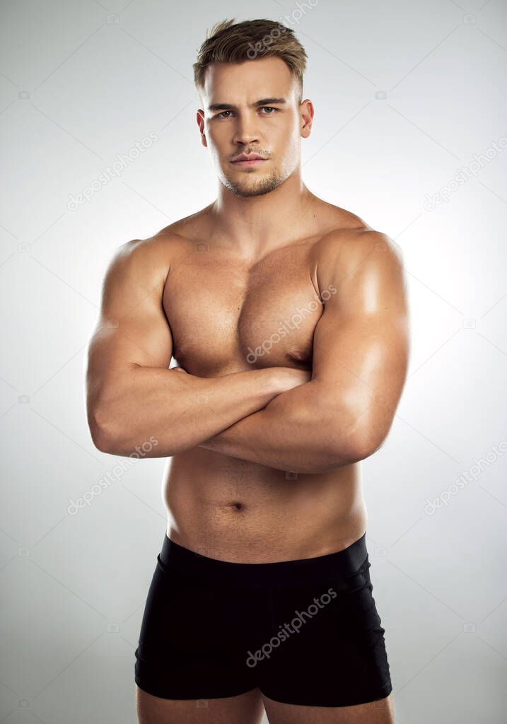 Some people want average, I desire great. Studio portrait of a muscular young man posing with his arms crossed against a grey background.