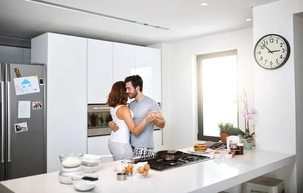 Más cerca de lo que nunca imaginamos. Tiro de pareja joven bailando en la cocina mientras se prepara el desayuno. —  Fotos de Stock