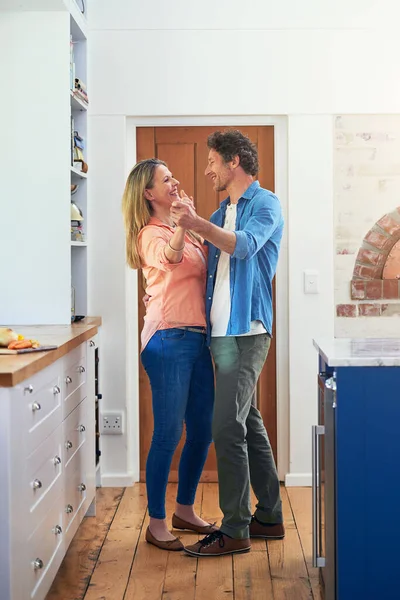 Romance é uma dança na cozinha. Tiro de um feliz casal maduro dançando juntos em casa. — Fotografia de Stock