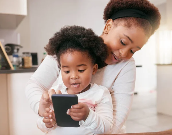 Wie wil je een bericht sturen? Foto van een klein meisje spelen met haar moeders smartphone. — Stockfoto