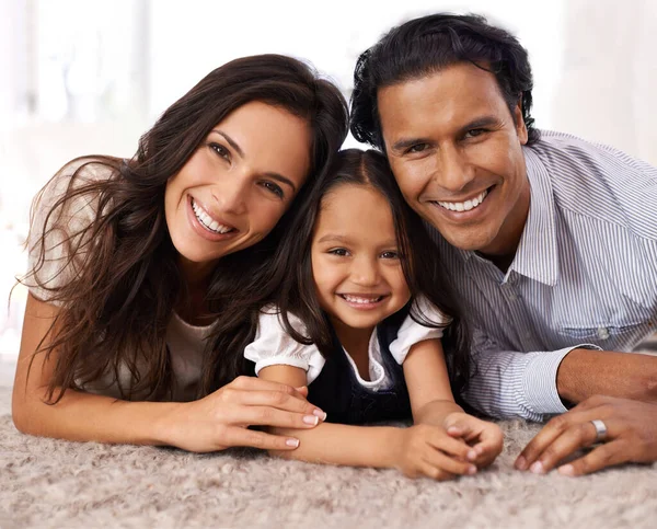 Uma família feliz. Retrato cortado de uma família jovem afetuosa em casa. — Fotografia de Stock