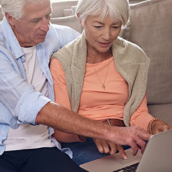Fazendo desejo on-line juntos. Tiro de um casal de idosos usando um laptop em casa. — Fotografia de Stock