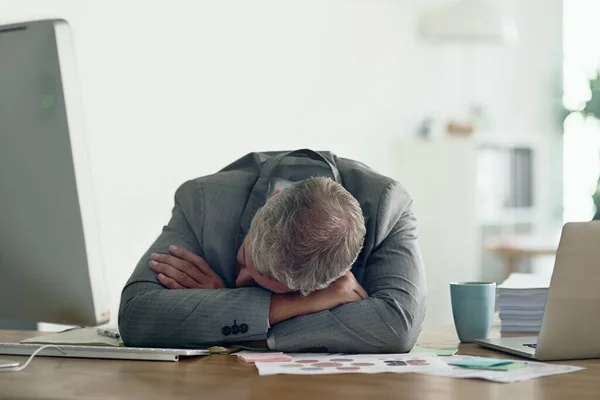 Così tante scadenze, così poco tempo. Colpo di un uomo d'affari esausto appoggiato sulle braccia alla scrivania. — Foto Stock