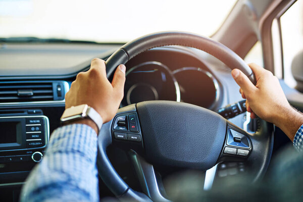 Always on the go. Cropped shot of an unidentifiable man driving a car.