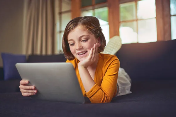 Její úplně první deska. Snímek rozkošné holčičky pomocí digitálního tabletu na podlaze doma. — Stock fotografie