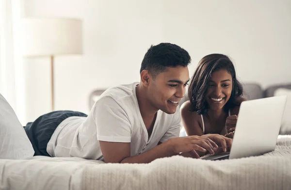 Wir können uns nie entscheiden, was wir gemeinsam gucken. Aufnahme eines jungen Paares mit einem Laptop zu Hause. — Stockfoto