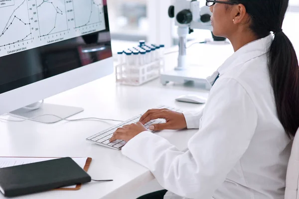 Ze is een genie achter de computer. Gehakte opname van een onherkenbare jonge vrouwelijke wetenschapper die in het laboratorium aan haar computer werkt. — Stockfoto