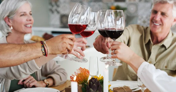 Aquí están los amigos que se sienten como familia. Foto de dos parejas felices sentadas para almorzar y brindar con copas de vino en casa. — Foto de Stock