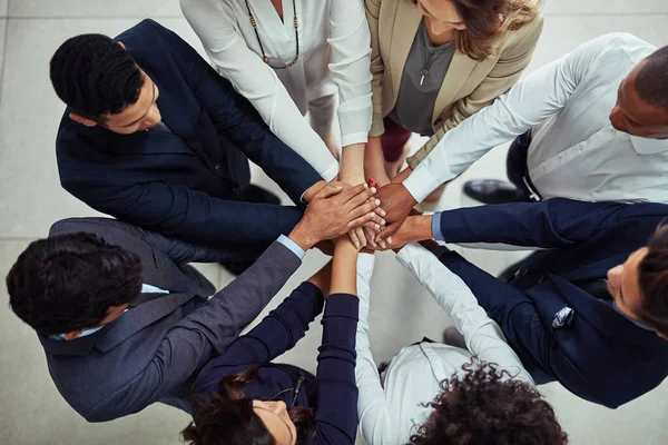 A grandeza só pode ser alcançada com o apoio de todos. Tiro de alto ângulo de um grupo de empresários unindo as mãos em unidade. — Fotografia de Stock