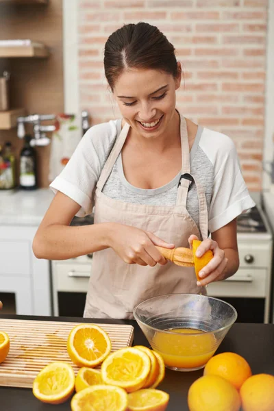 Естественно лучше. Снимок привлекательной женщины, готовящей свежий апельсиновый сок на кухне. — стоковое фото