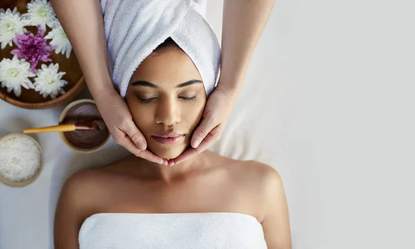 This is the most relaxed Ive ever felt. Shot of a young woman getting a facial treatment at a spa. — Stock Photo, Image