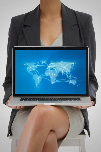 Мир никогда не был так соединен. Студийный снимок предпринимательницы с ноутбуком, показывающий карту мира с местоположениями на ней. — стоковое фото
