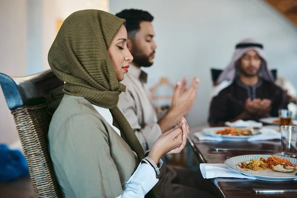 Giving thanks for a bountiful feast. Shot of a muslim family praying before they break their fast. — ストック写真