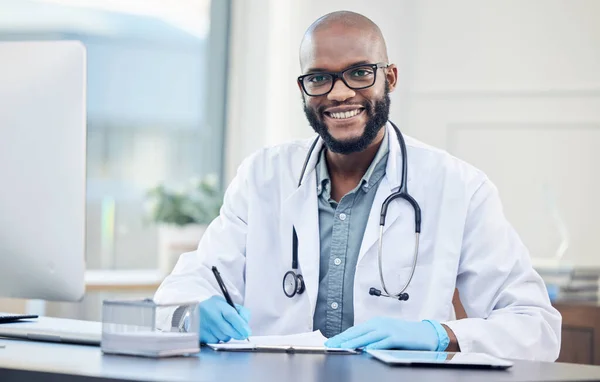 Hoe kan ik je beter laten voelen. Schot van een knappe jonge dokter die alleen in zijn kliniek zit en aantekeningen maakt.. — Stockfoto