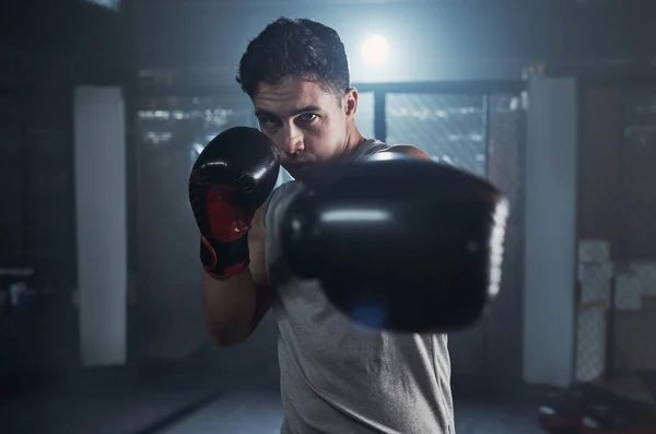 Bemoei je niet met mijn spieren. Portret van een jongeman die zijn boksroutine oefent in een sportschool. — Stockfoto