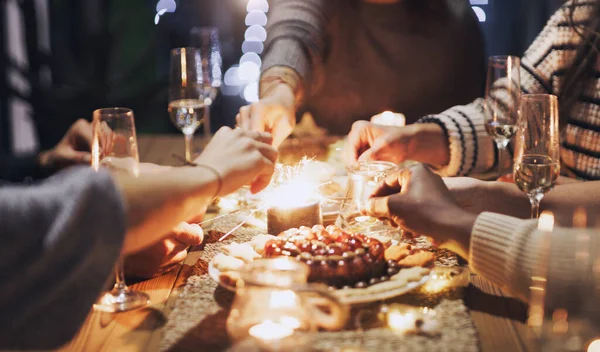 Ilumina tu vida con buenos amigos. Recorte de un grupo de amigos jugando con bengalas en una cena de Navidad. — Foto de Stock