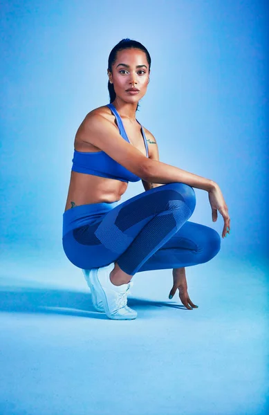 Vous seul pouvez transformer FAT en FIT. Plan complet d'une jeune sportive séduisante posant en studio sur fond bleu. — Photo