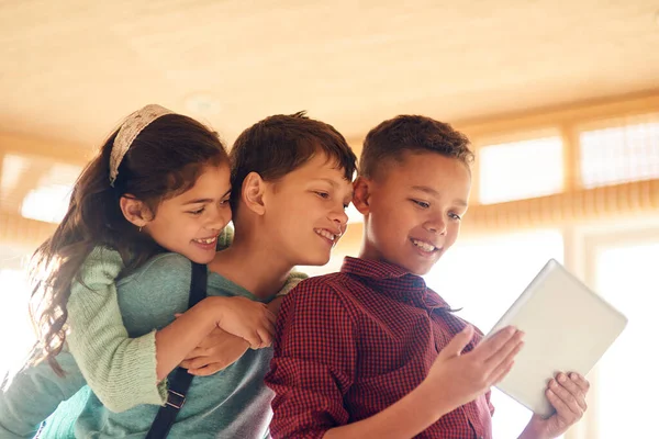 Hoy en día los niños son más conocedores de la tecnología. Fotografía de niños pequeños usando una tableta digital juntos en casa. —  Fotos de Stock