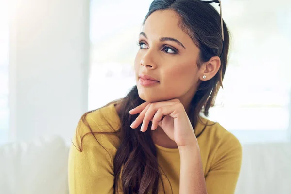 Spending some time alone with my thoughts. Shot of a beautiful young woman relaxing at home. — Stock Photo, Image