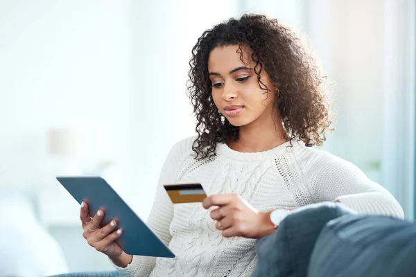 Daha akıllıca alışverişler yap. Dijital tablet kullanırken kredi kartını tutan genç bir kadının fotoğrafı.. — Stok fotoğraf