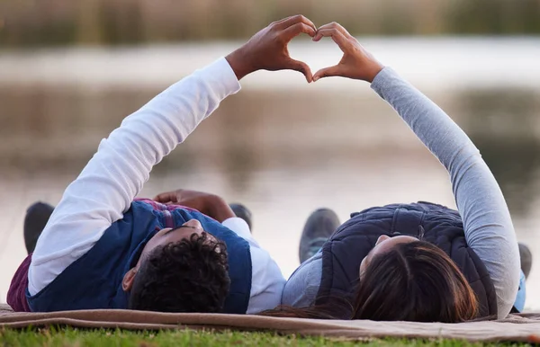 Mon cœur est plein de toi. Prise de vue d'un couple créant une forme de coeur avec leurs mains lors d'un voyage de camping. — Photo