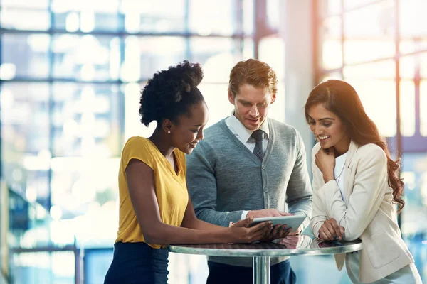 Sfruttando nuovi mercati per ampliare la loro portata. Foto ritagliata di un gruppo eterogeneo di uomini d'affari che lavorano insieme su un tablet digitale in un ufficio. — Foto Stock